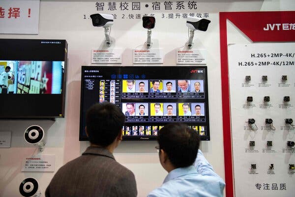 Visitors looking at artificial intelligence security cameras with facial recognition technology at the China International Exhibition on Public Safety and Security in Beijing in 2018.